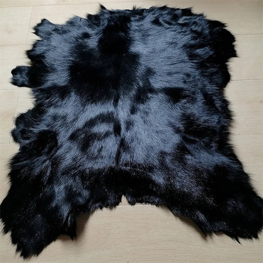 Eine ganze schwarze Schaffellmatte. Sofakissen aus Wolle. Eine einteilige Pelzmatte für den Schlafzimmerhocker. Pelzkragen für Lederjacke So ist Leben