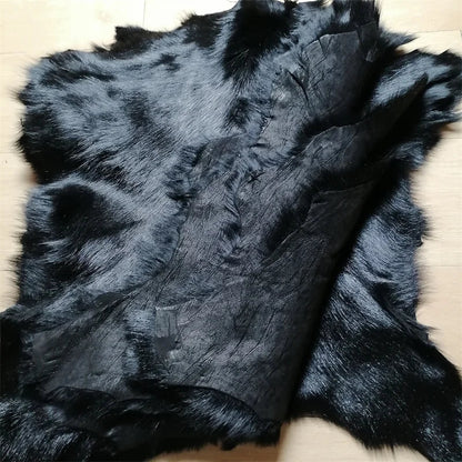 Eine ganze schwarze Schaffellmatte. Sofakissen aus Wolle. Eine einteilige Pelzmatte für den Schlafzimmerhocker. Pelzkragen für Lederjacke So ist Leben