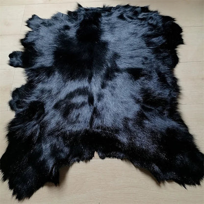 Eine ganze schwarze Schaffellmatte. Sofakissen aus Wolle. Eine einteilige Pelzmatte für den Schlafzimmerhocker. Pelzkragen für Lederjacke So ist Leben